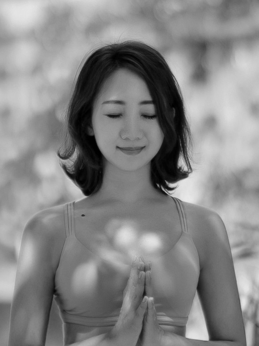 ヨガ講師 Asana のモノクロポートレート、目を閉じ穏やかな表情で胸の前で合掌している