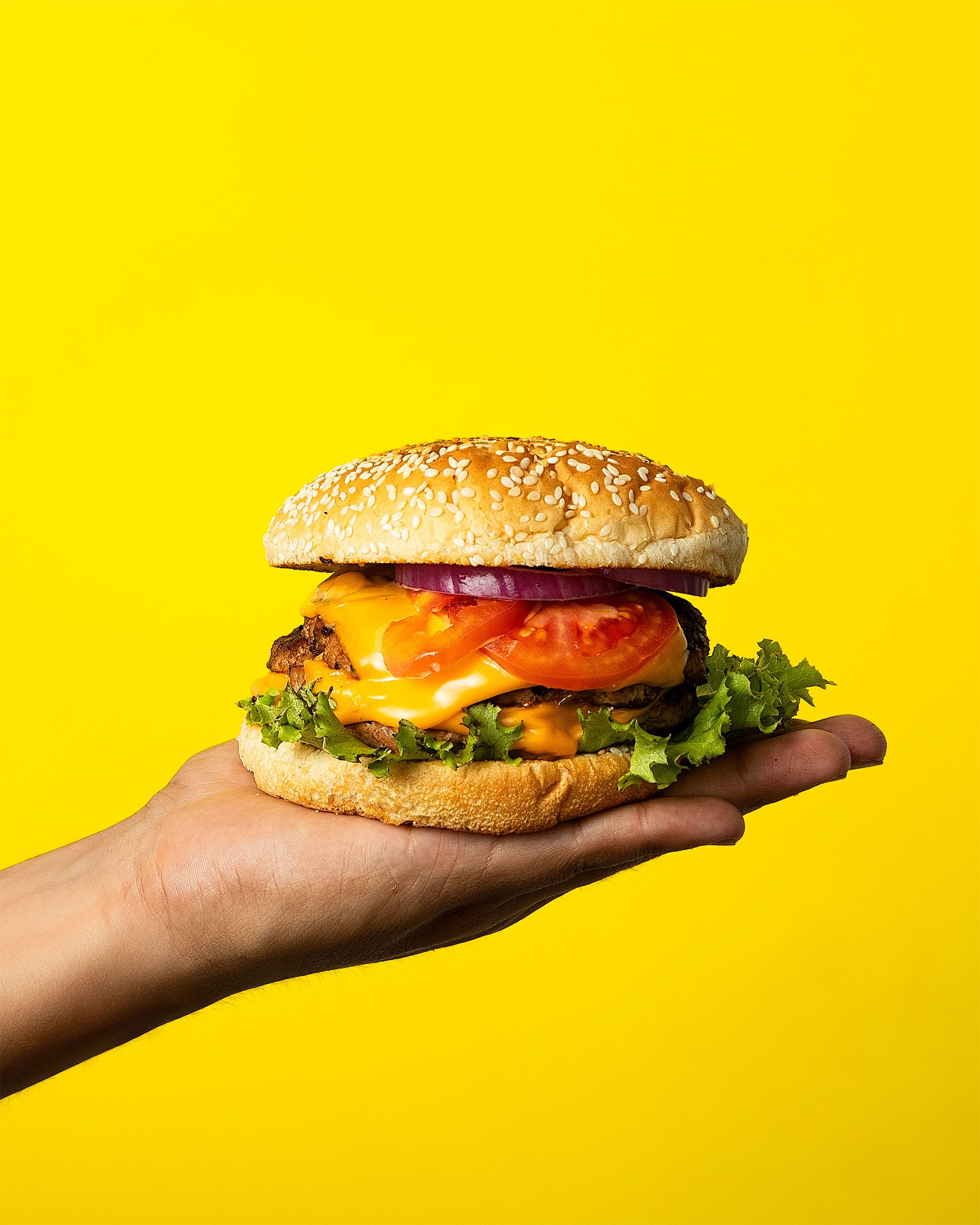 STACKのチーズバーガーを手に持つ